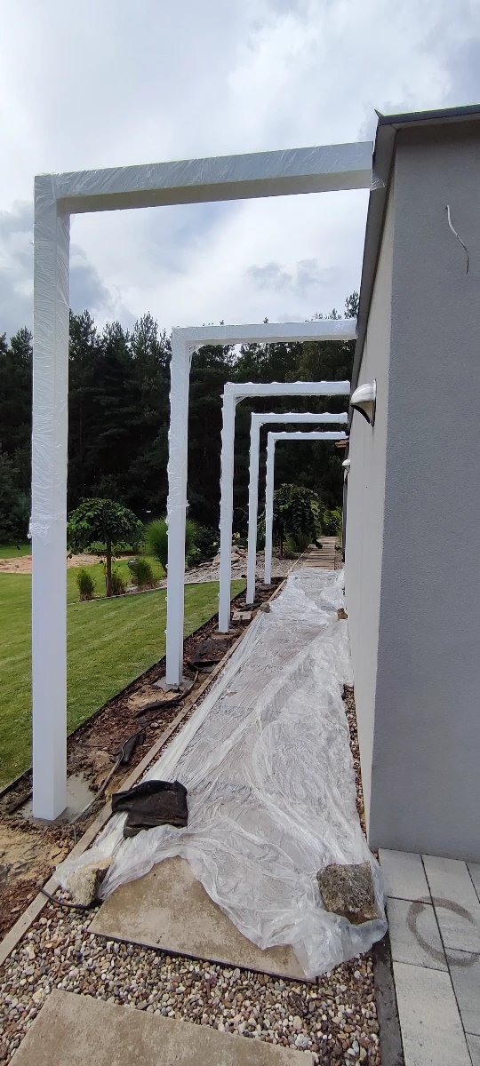 Metalowe białe pergole tarasowe przy budynku zabezpieczone powłoką proszkową